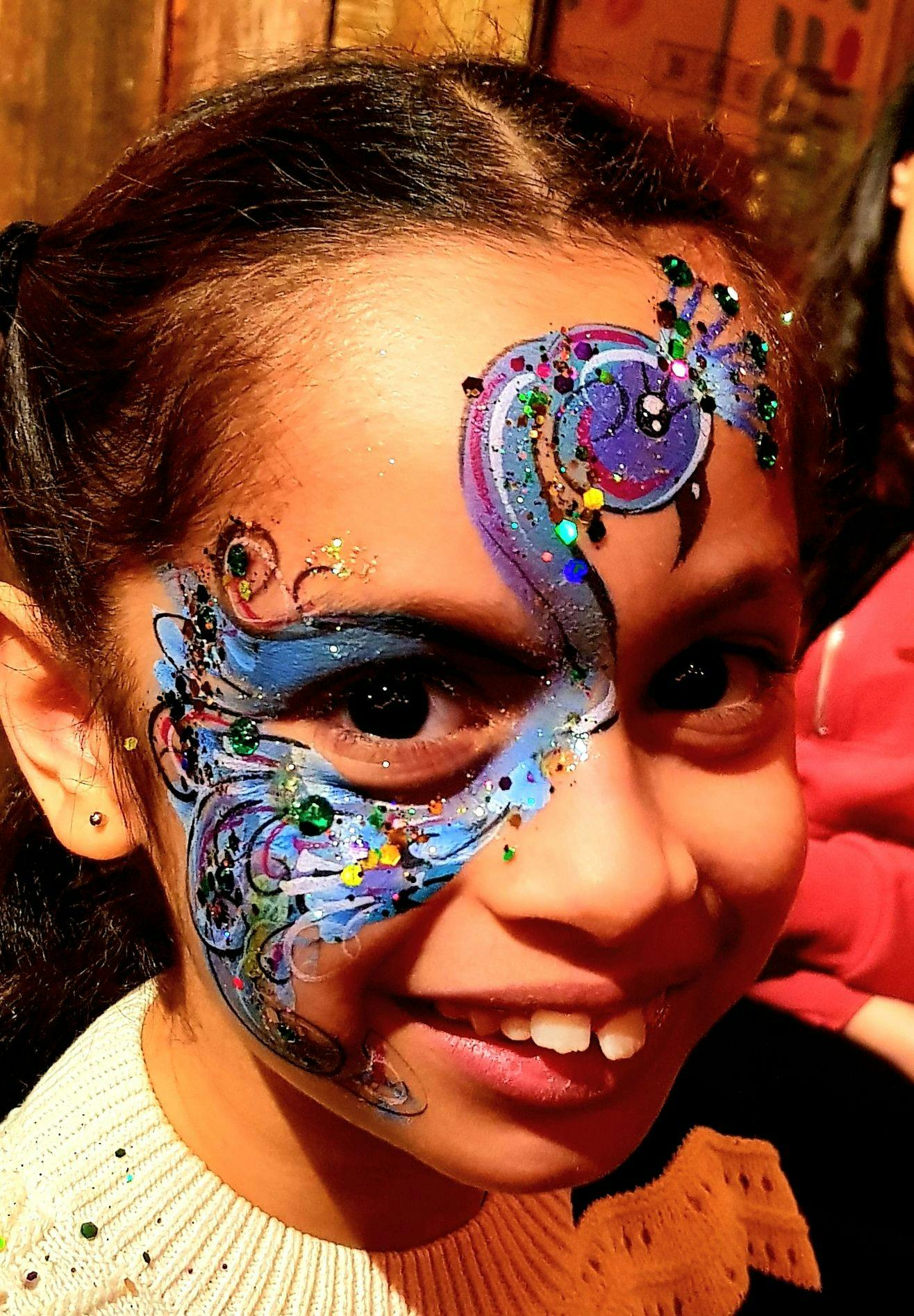 A child smiling with her face painted.