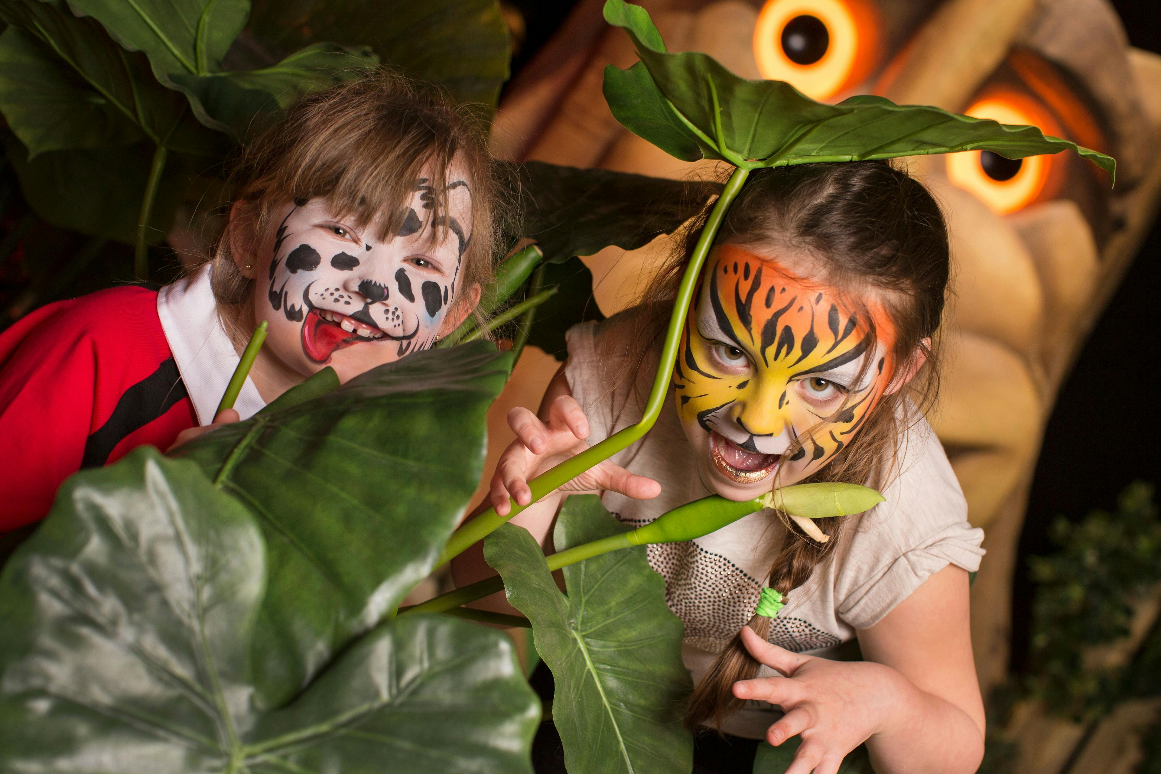 Two children posing with their faces painted.