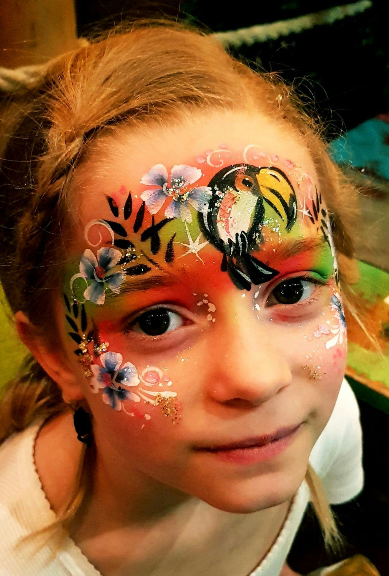 A young child posing with her face painted.