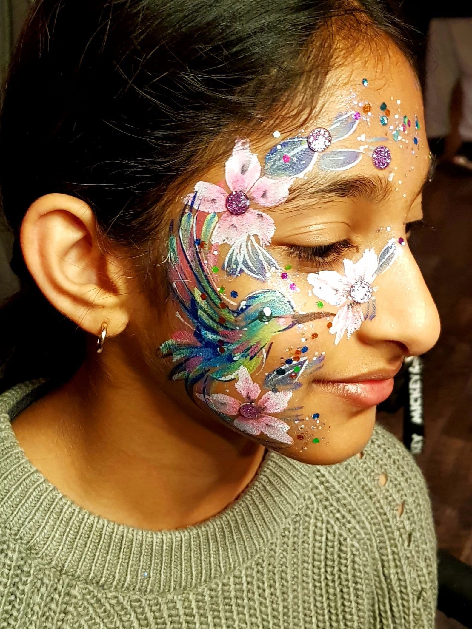 A child smiling with her face painted.