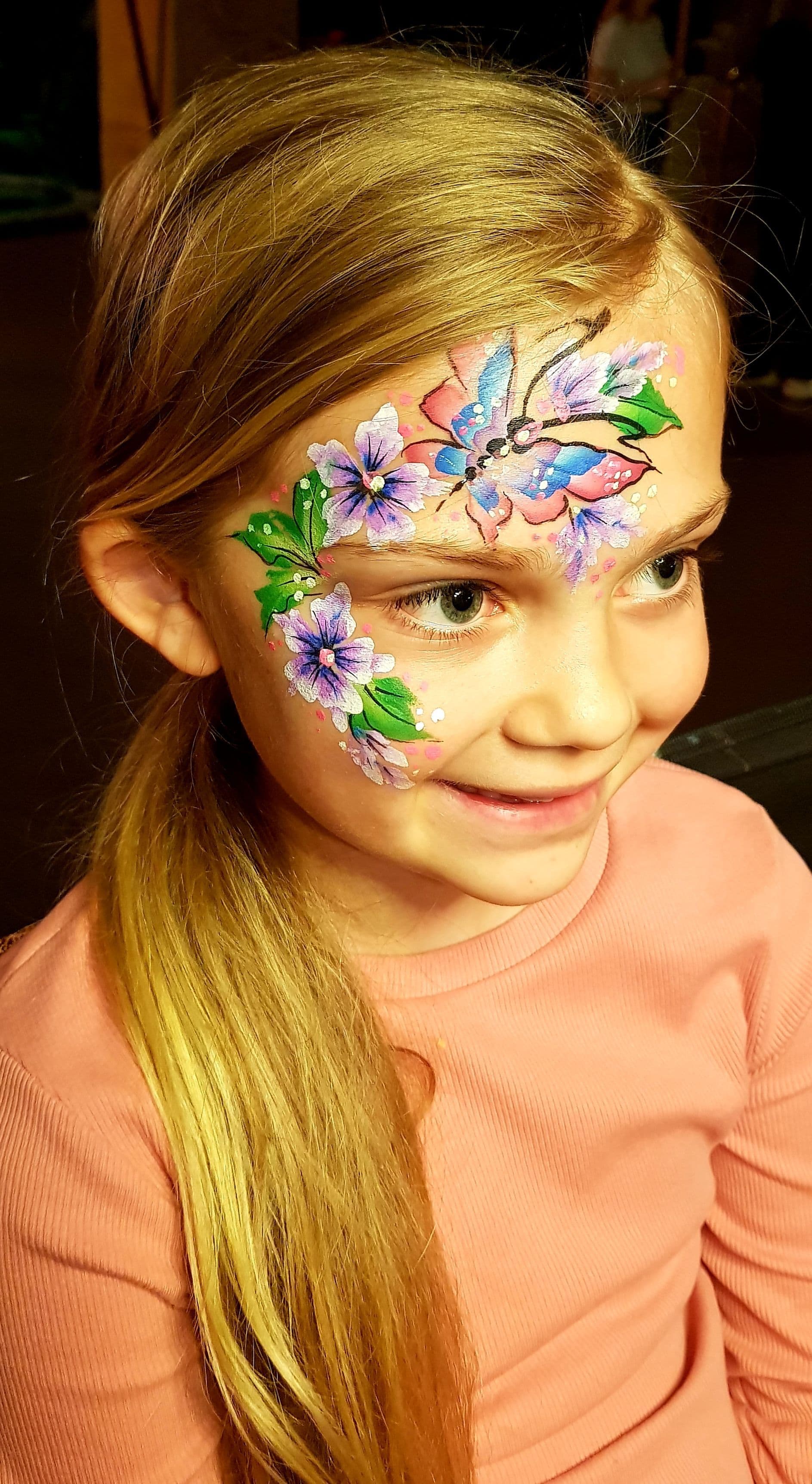 A child smiling with her face painted.