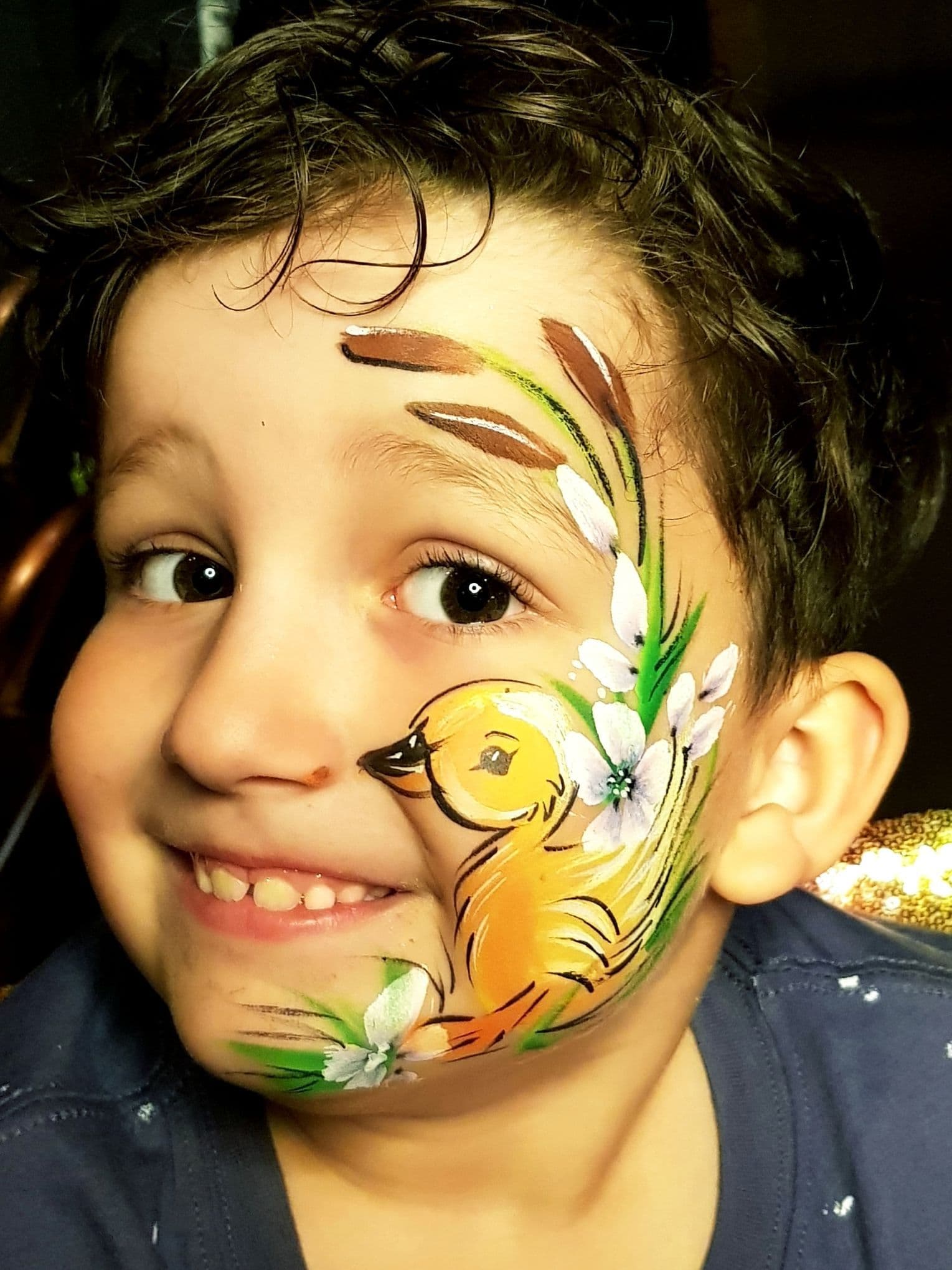 A child smiling with his face painted.