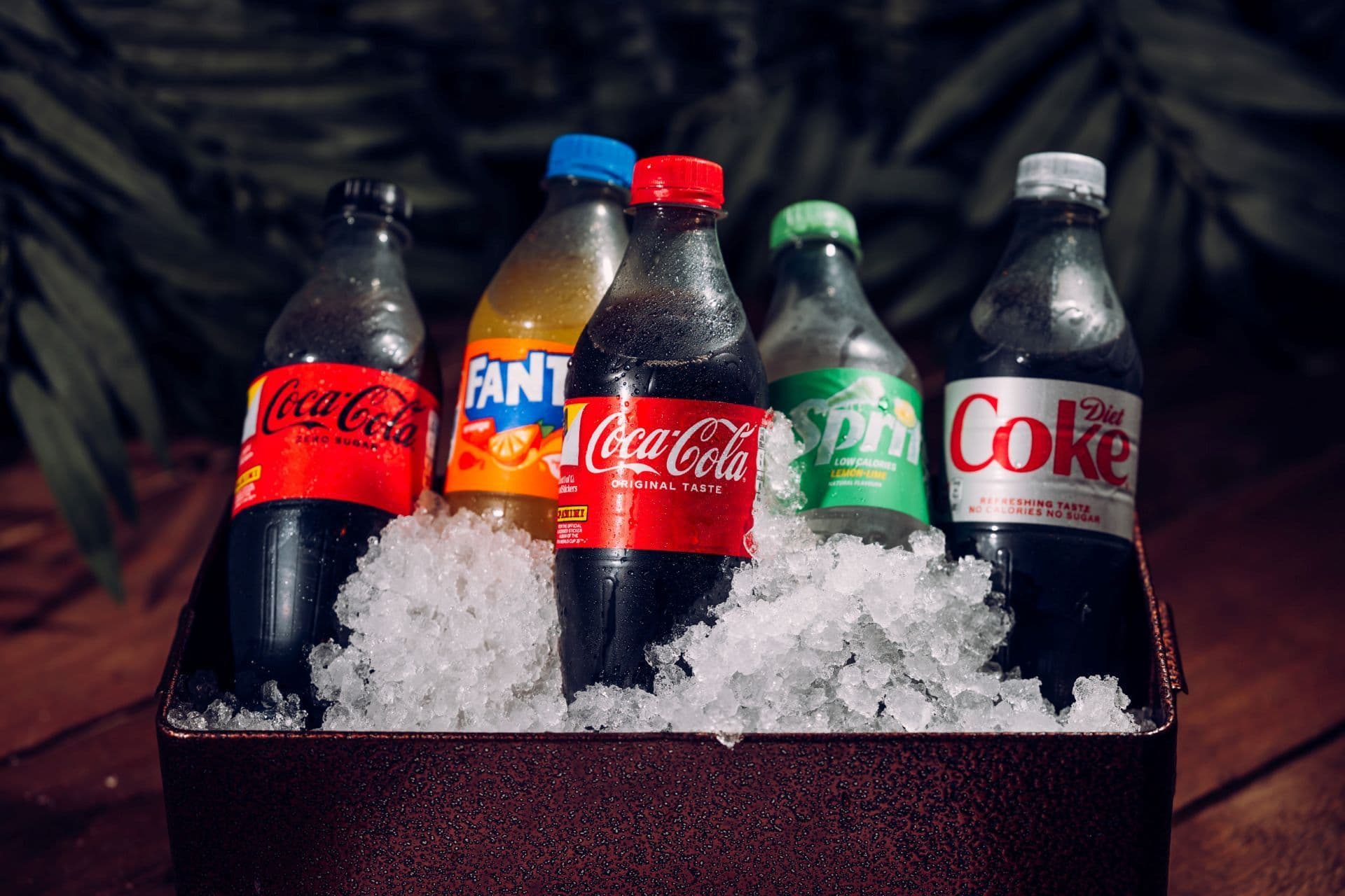 A selection of soft drinks displayed in a tray of ice.
