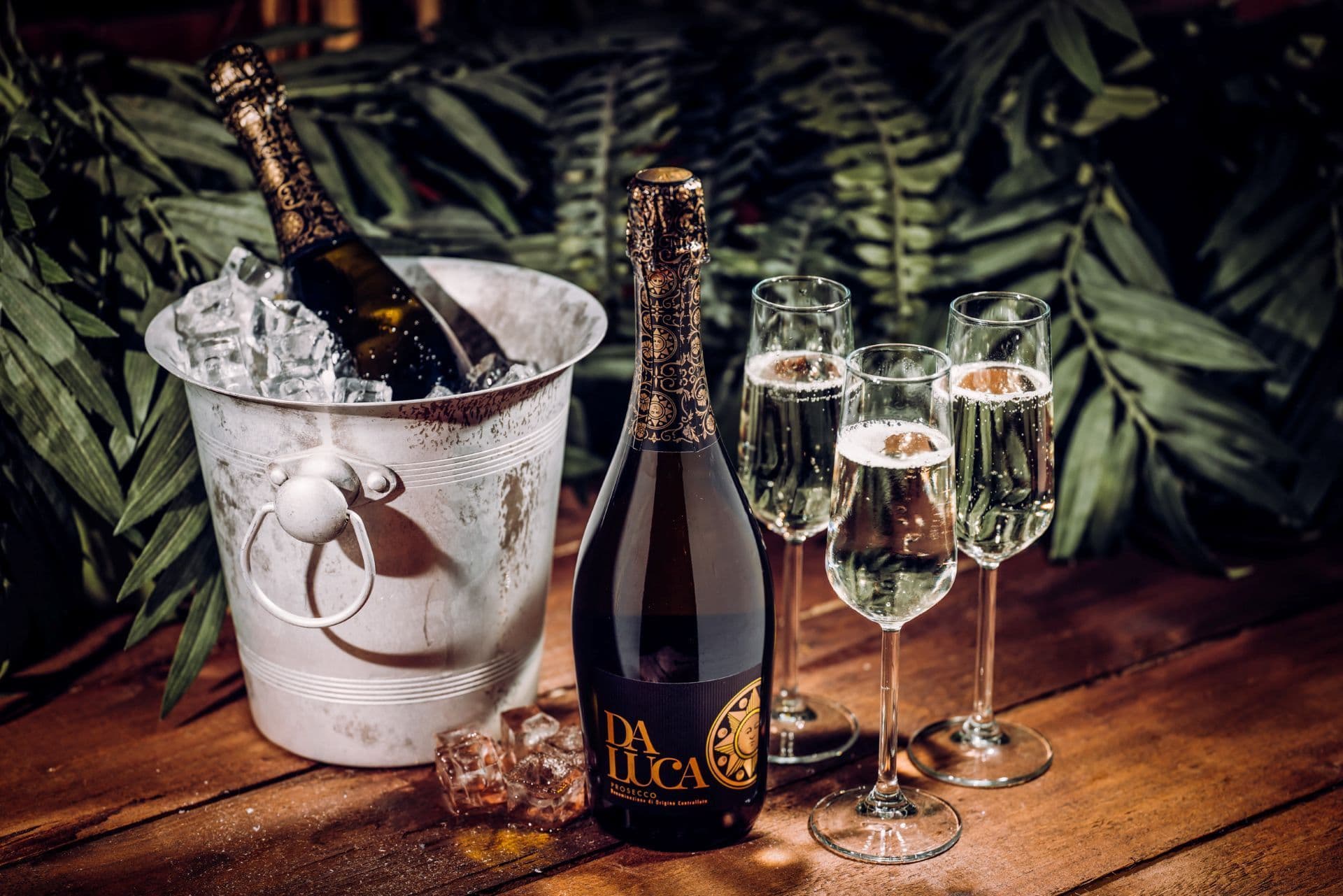 A bottle of prosecco displayed in a bucket of ice.