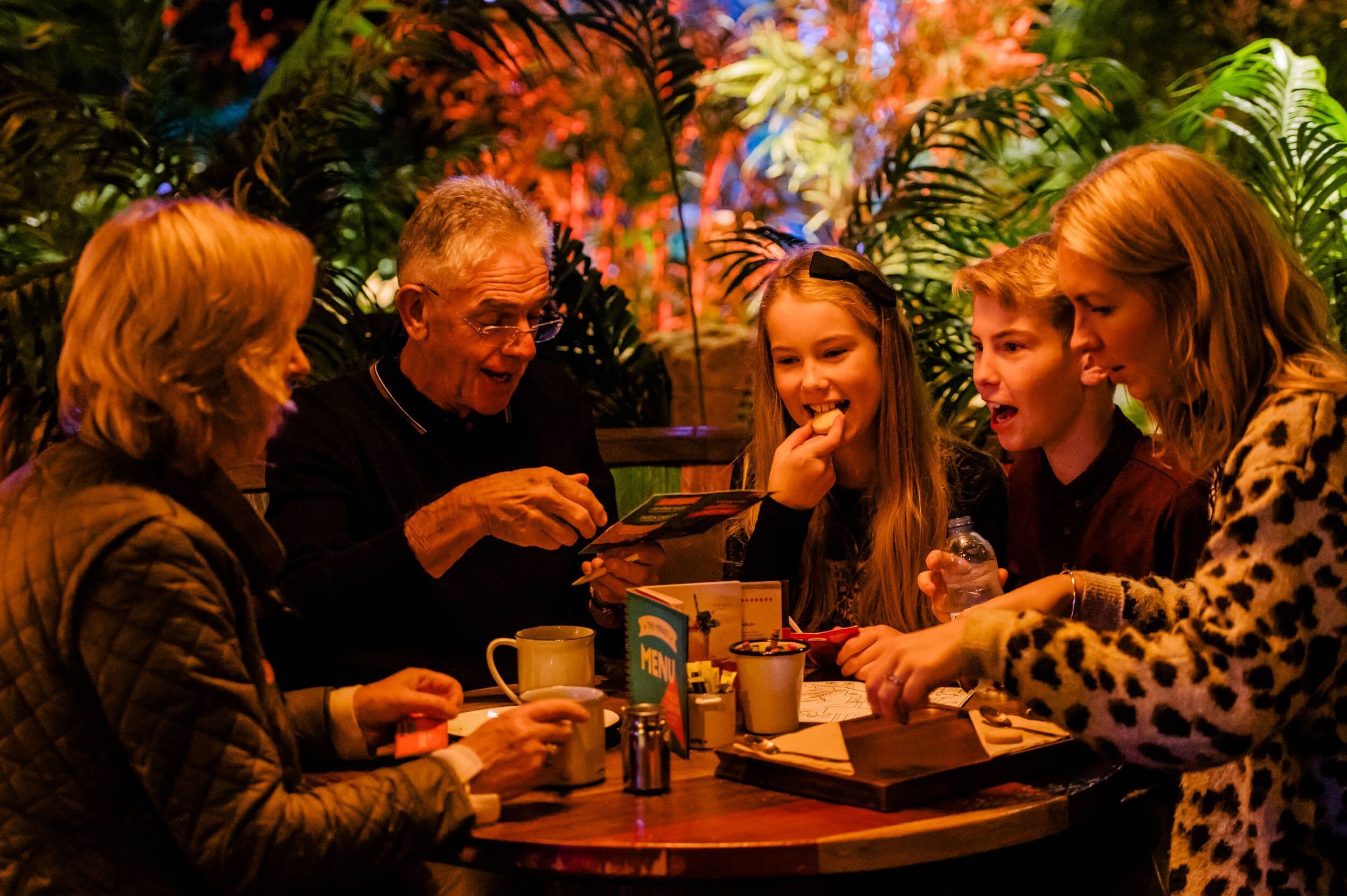 Family sitting down at the Market laughing.