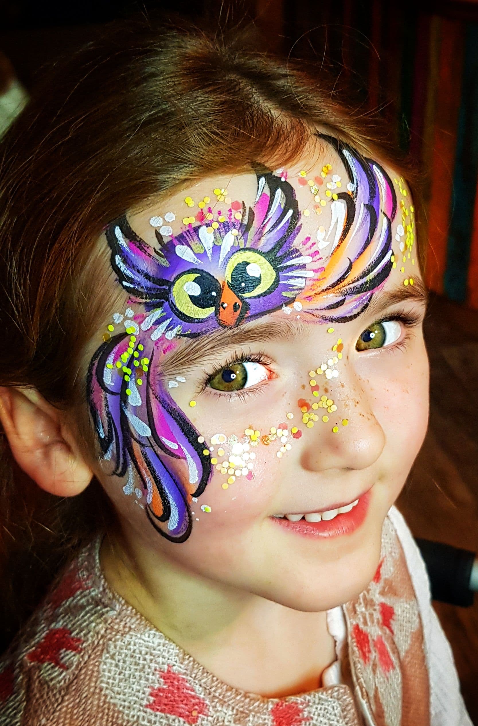 A child smiling with her face painted.