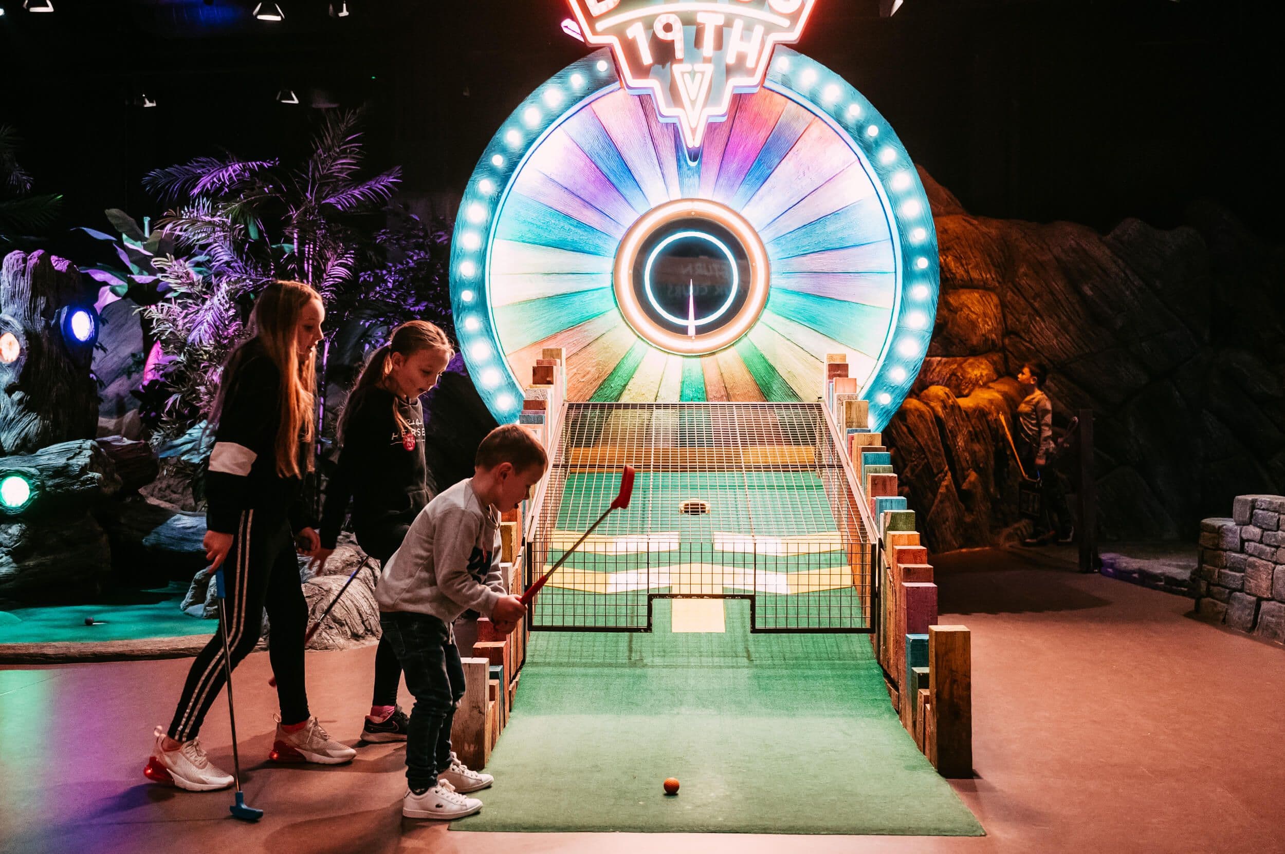 A small child getting ready to playing the bonus 19th hole.