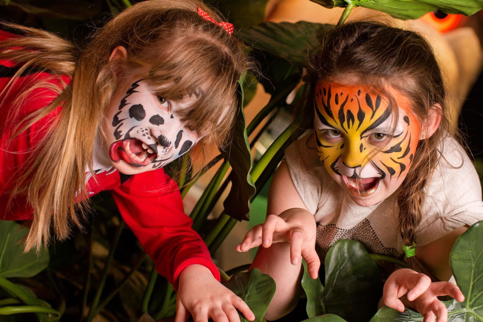 Two children posing with their face painted like animals at Treetop Golf.