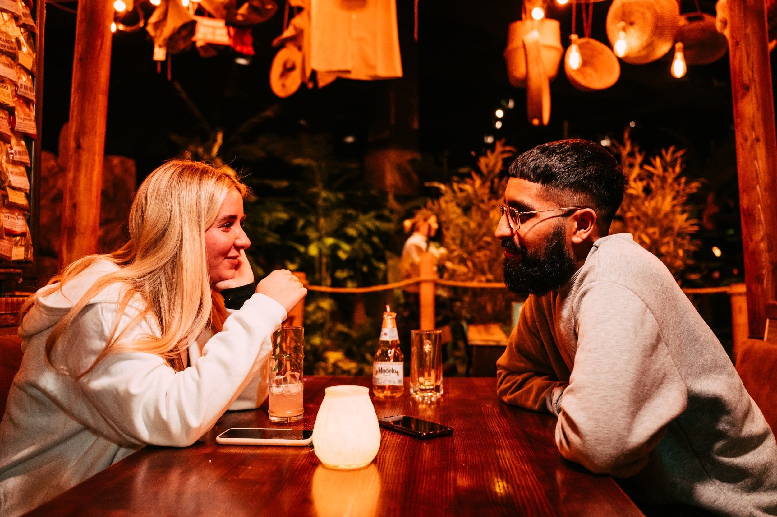 A young couple sitting having drinks together.