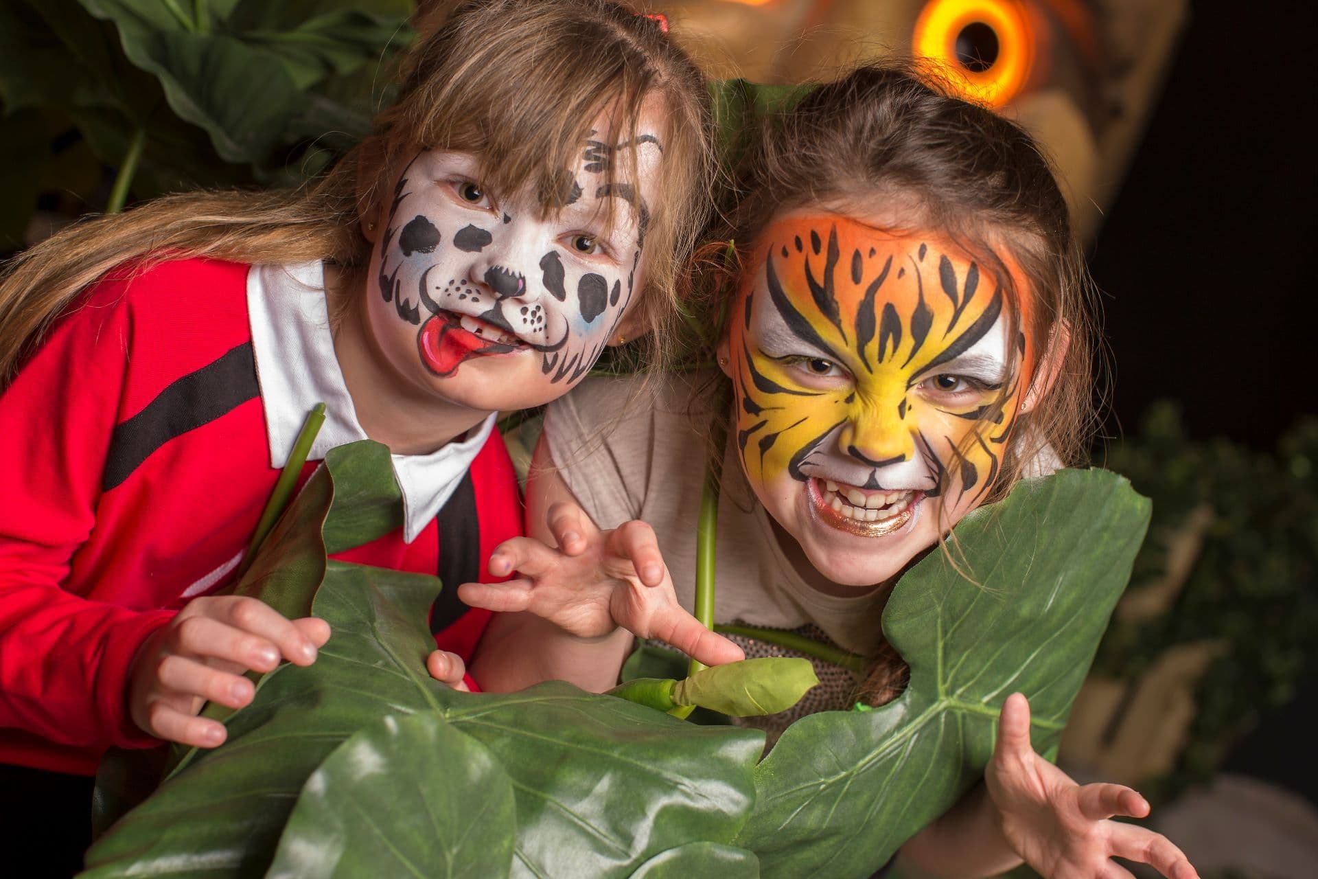 Two children posing with their faces painted.