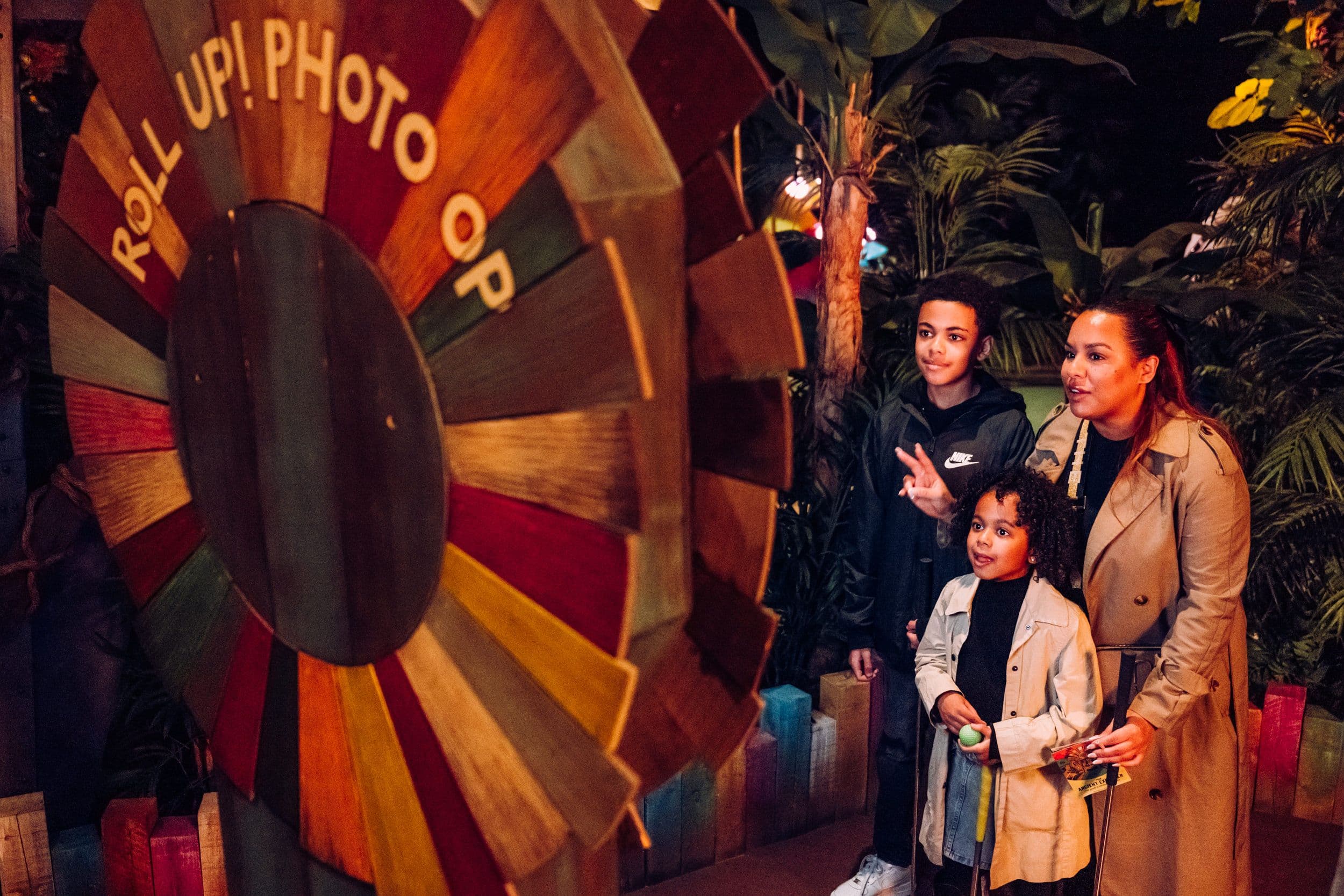 A young family posing for the Photobooth at Treetop Golf.