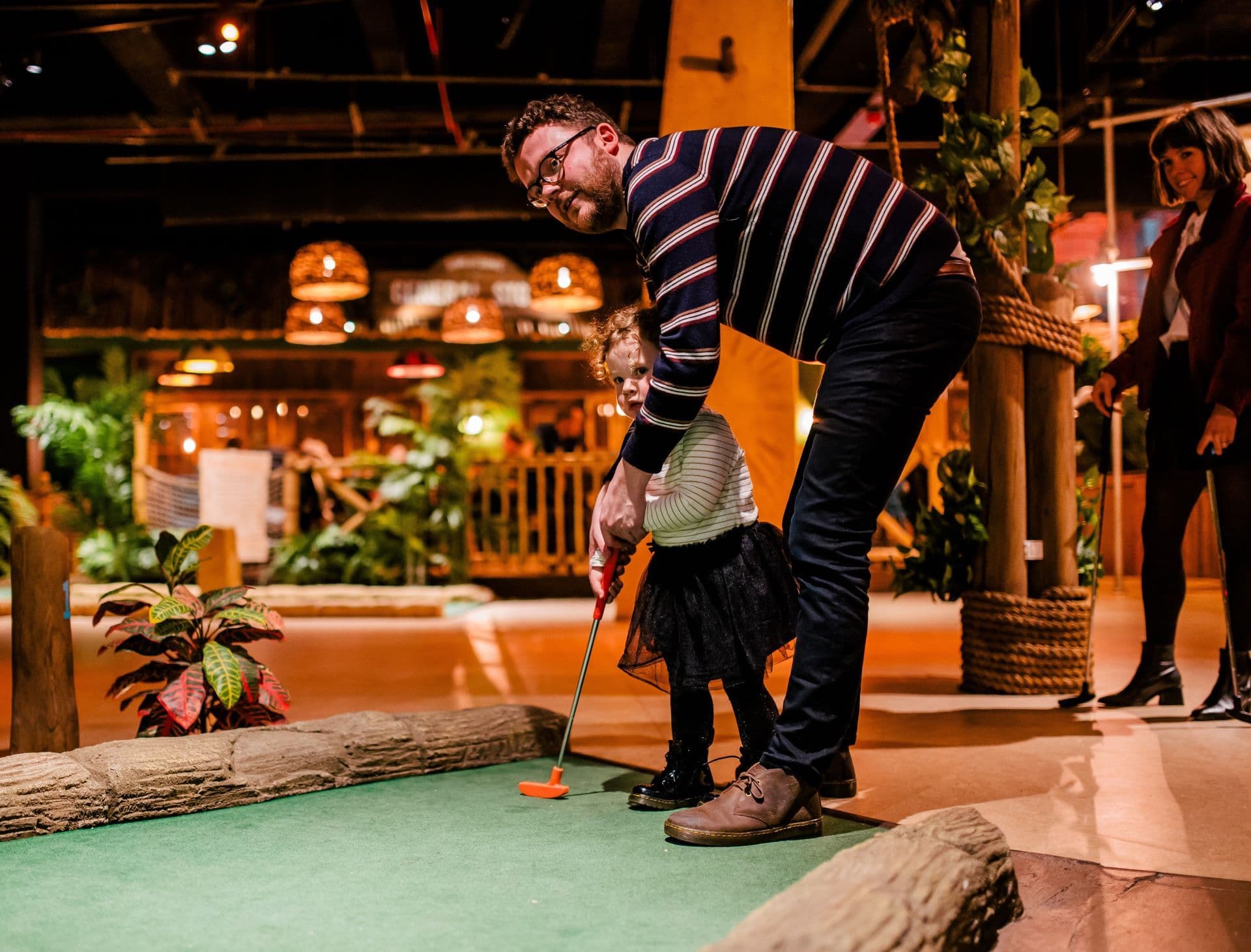 A Father and daughter playing mini golf at Treetop Golf.