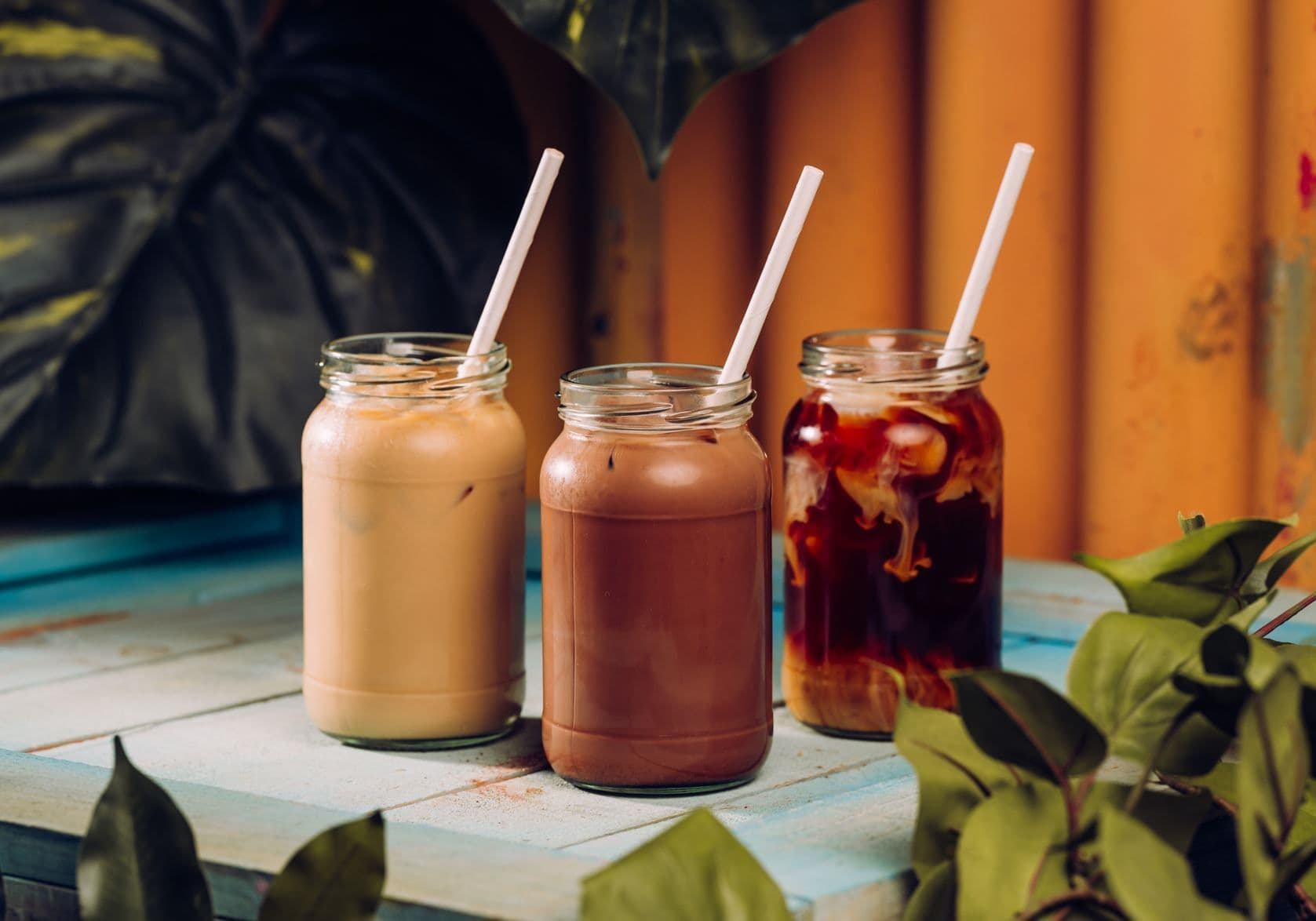 3 iced drinks lined up on a table.