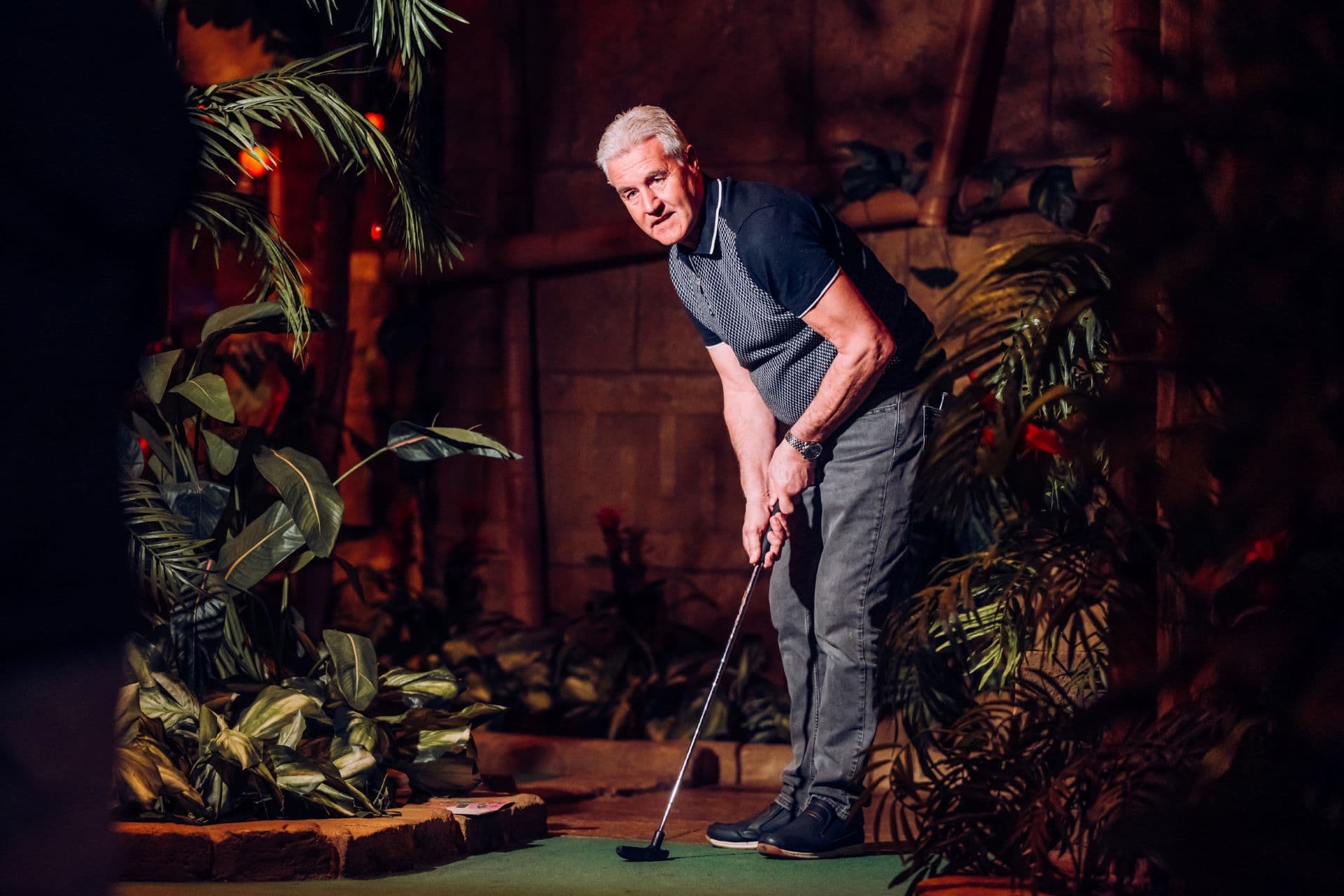 A man in a putting stance at Treetop Golf.