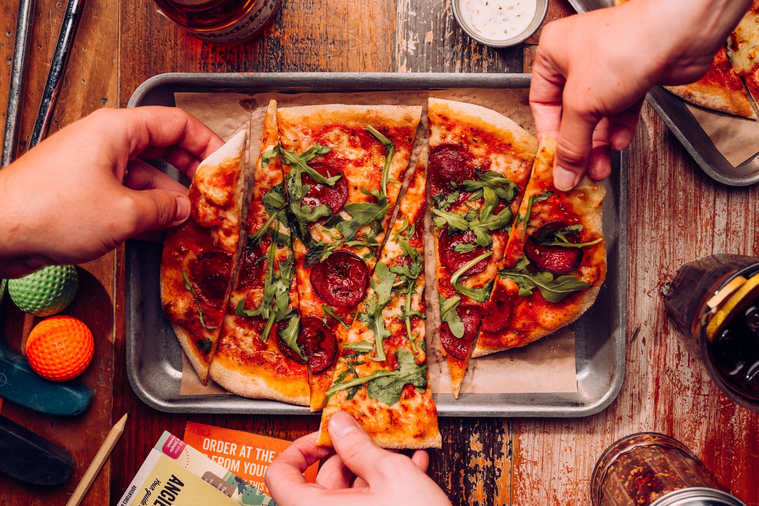 3 people sharing a Sizzle and Swing pizza.