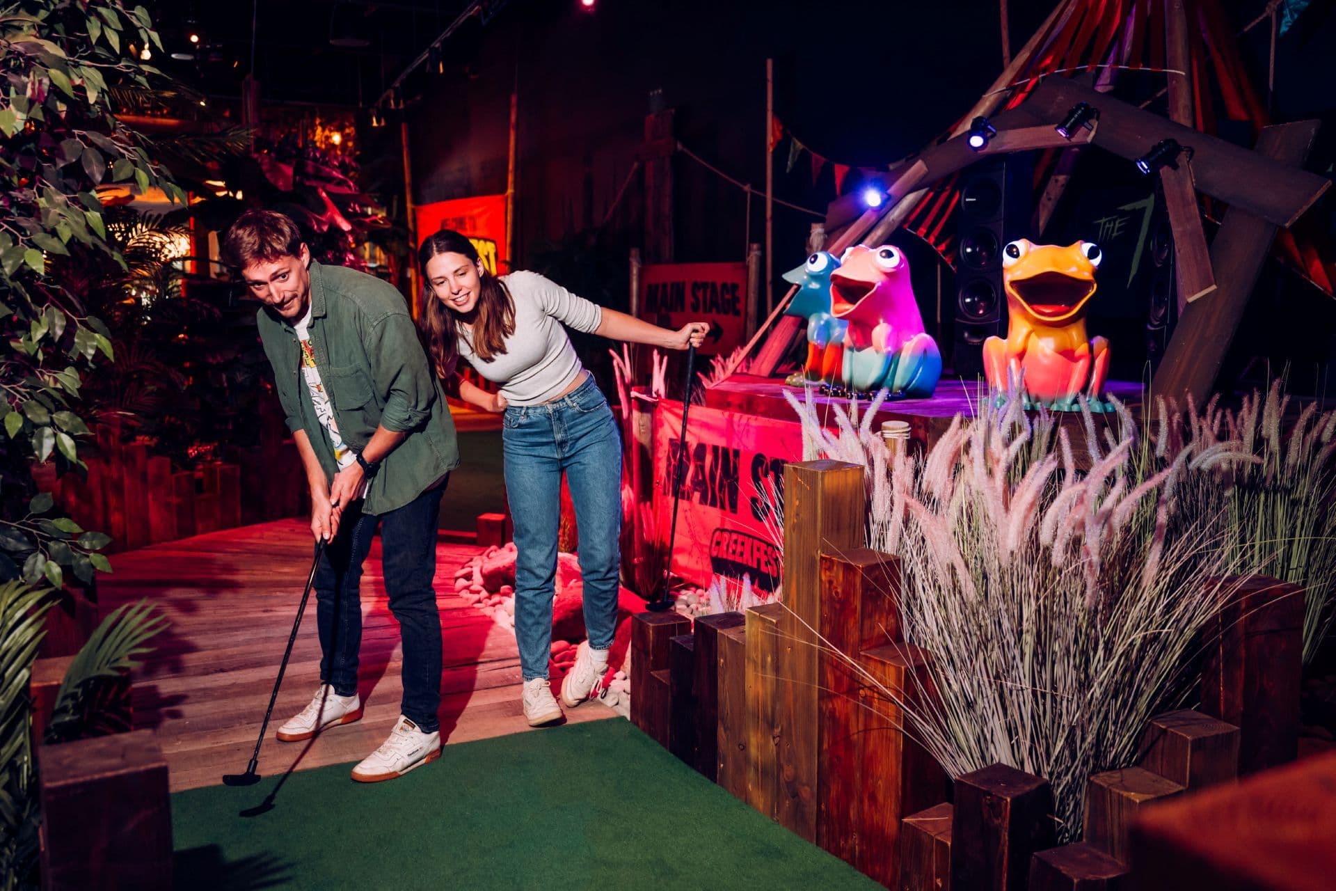 A young couple playing mini golf at Treetop Bristol