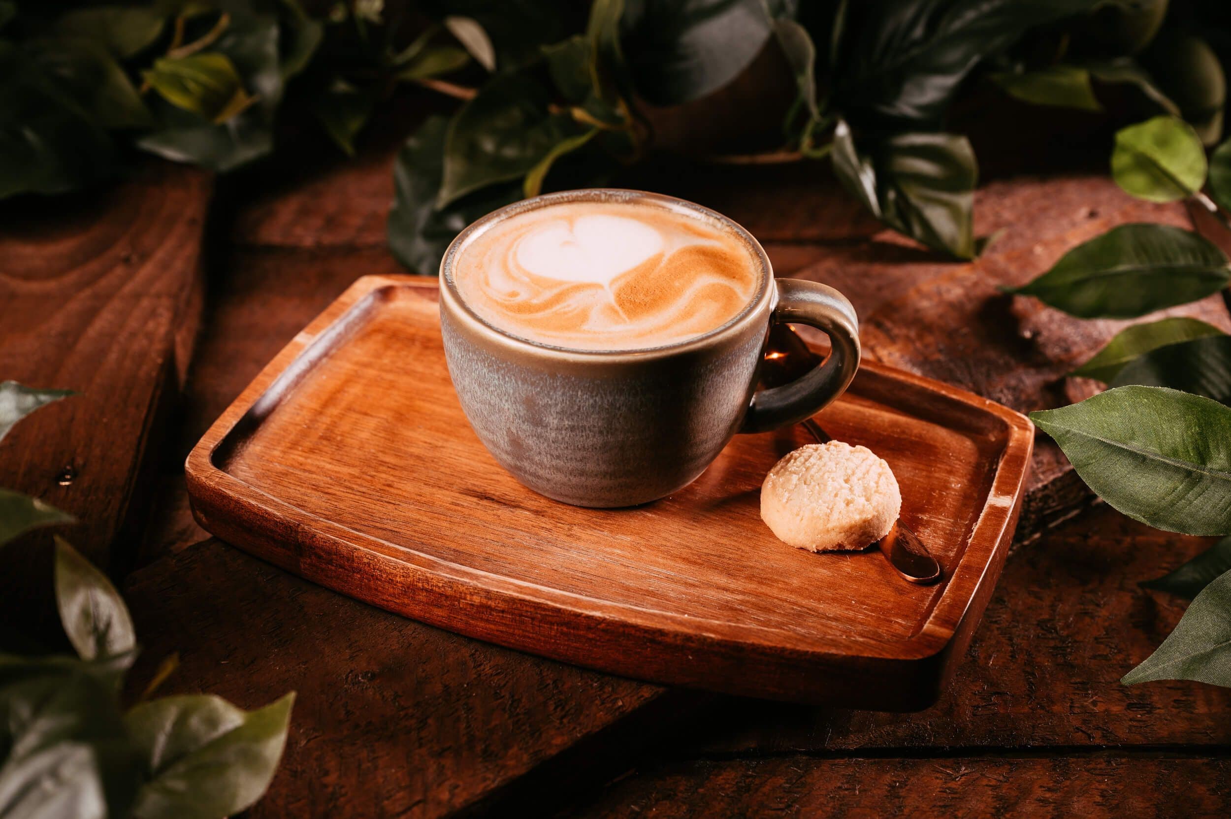 A latte positioned next to a biscuit at Treetop Golf.
