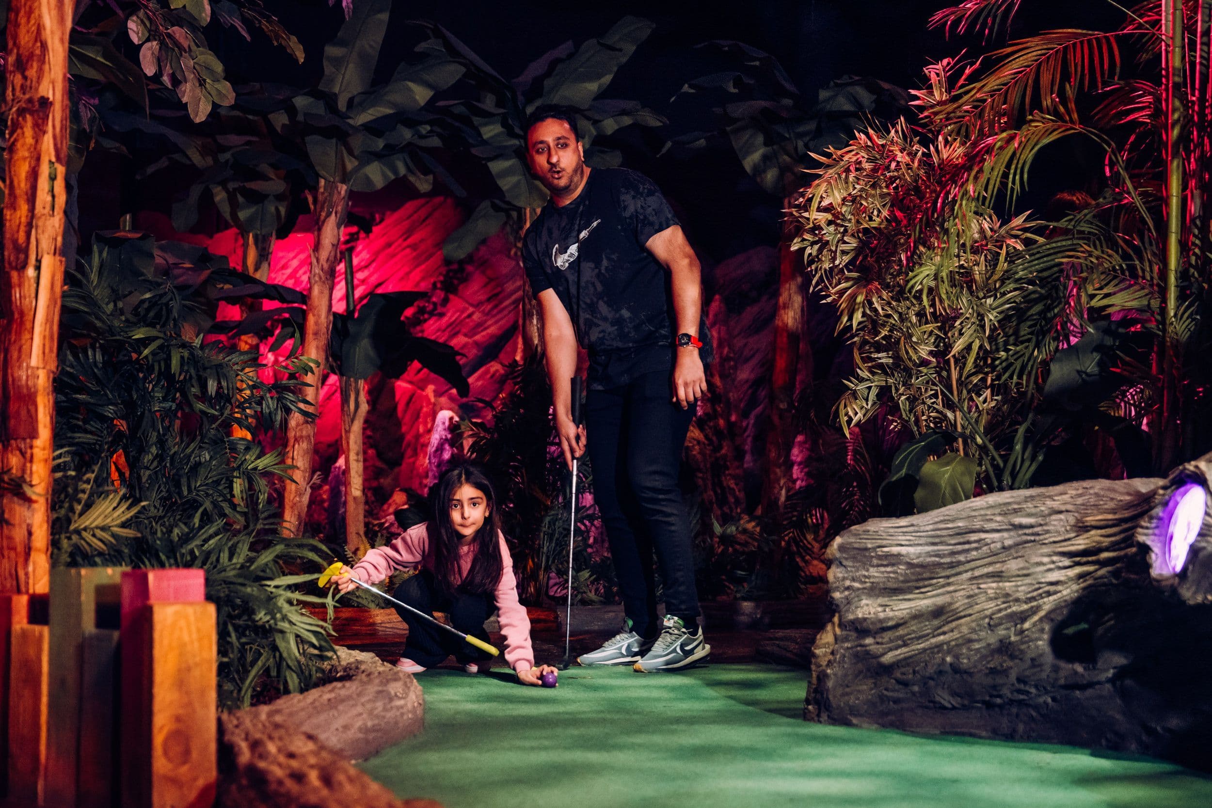 A father and daughter playing mini golf at Treetop