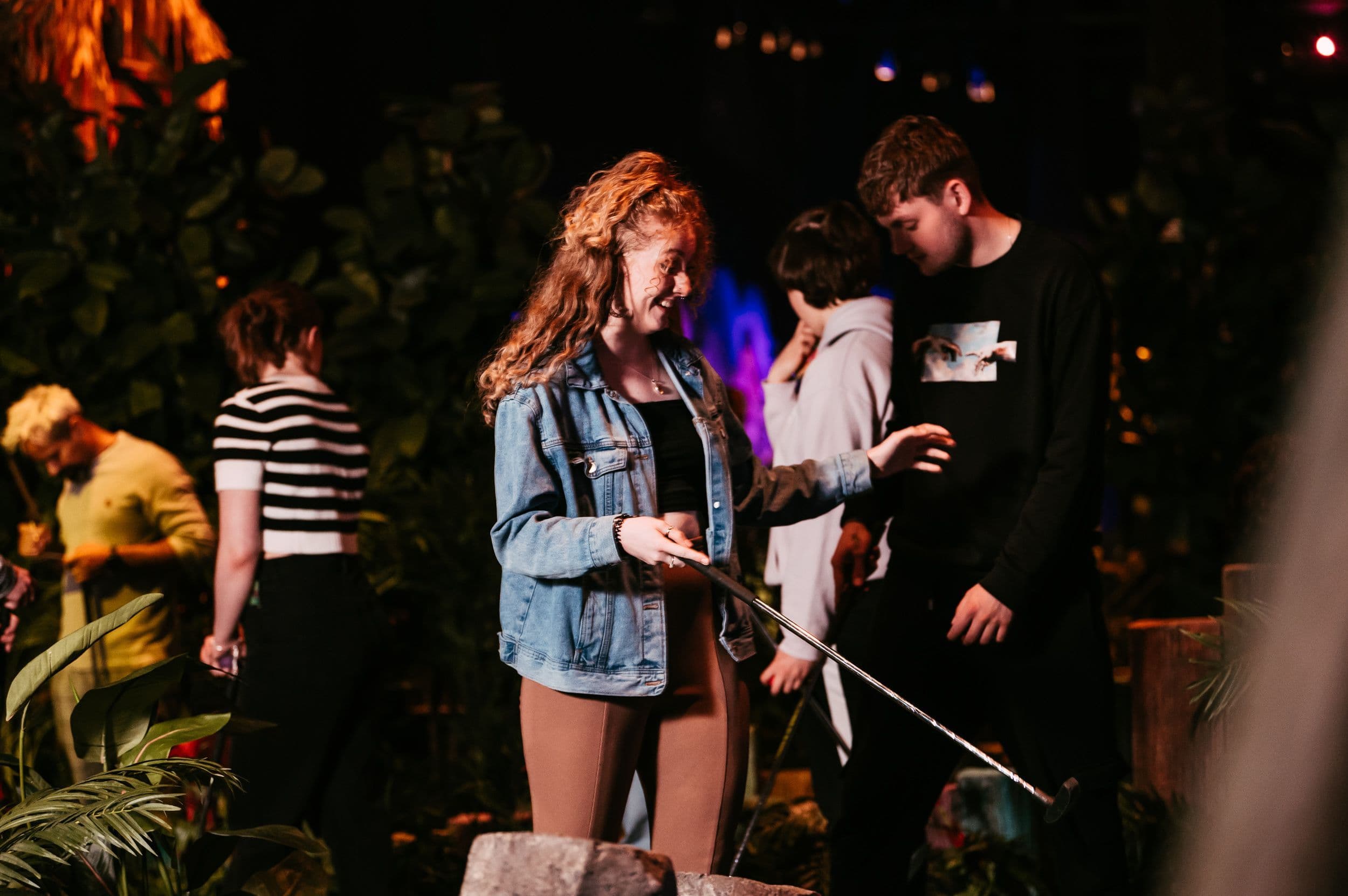 Adult lady smiling holding a golf club