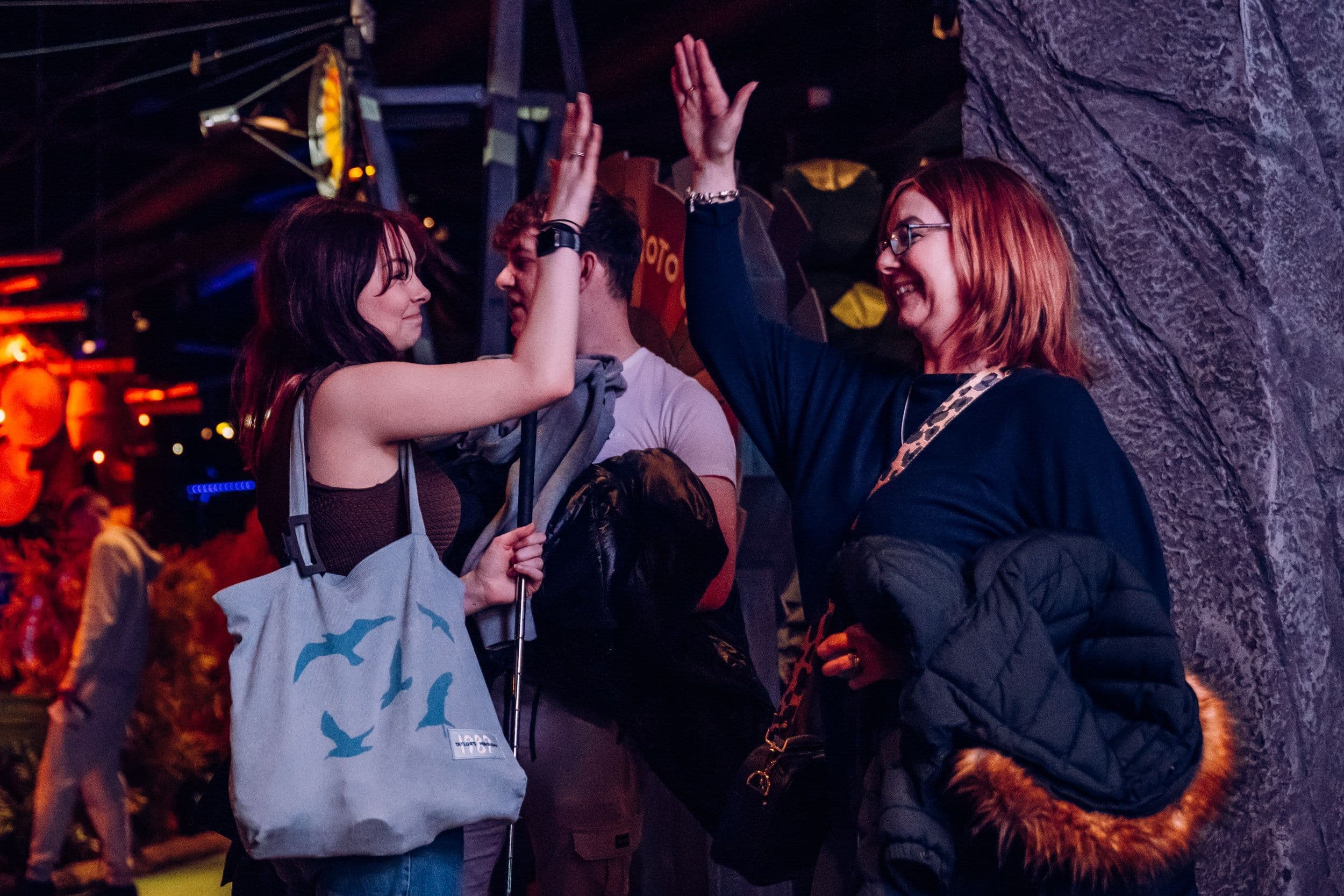 Two women high fiving at Treetop Golf.