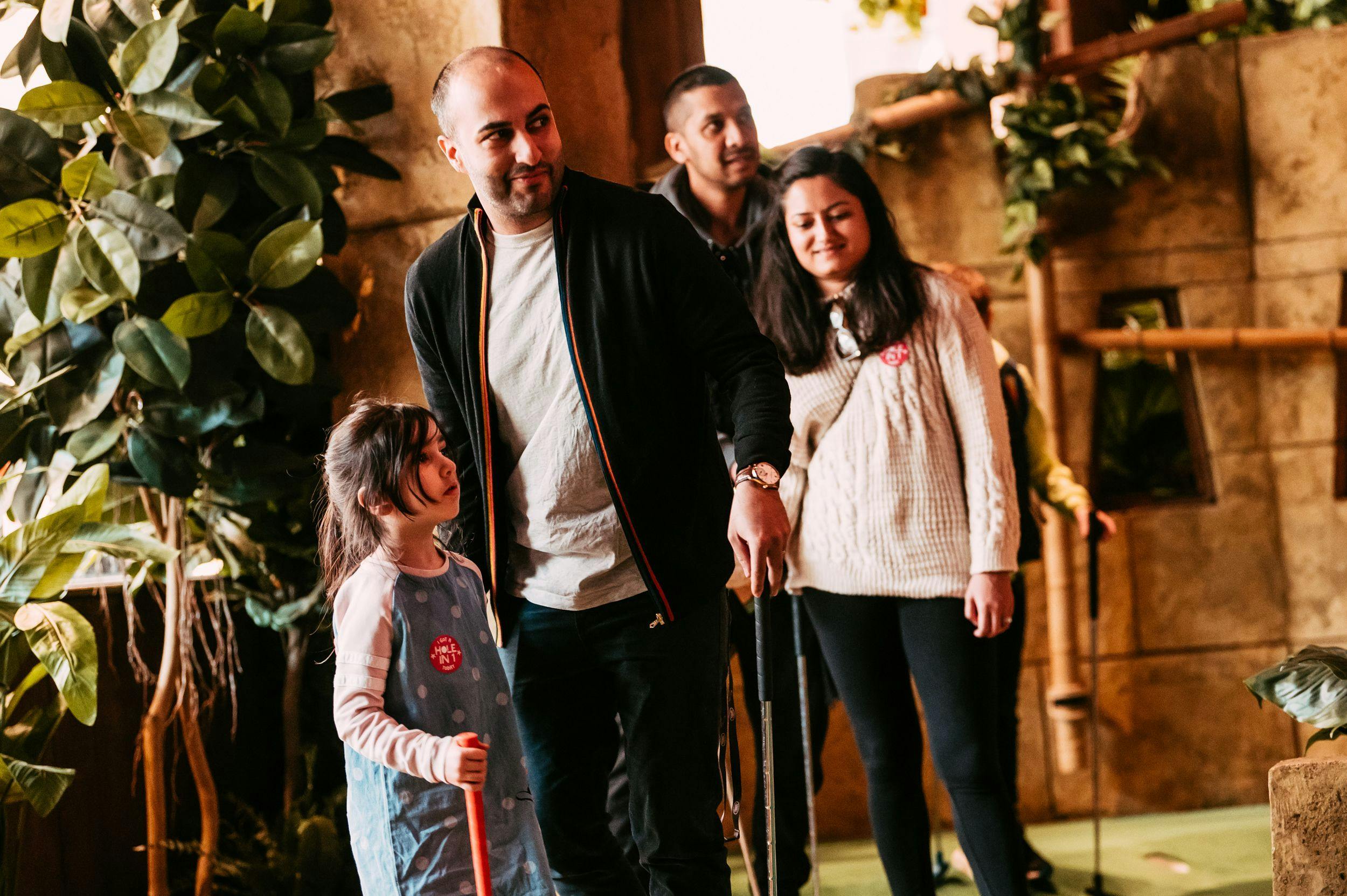 A family of 4 playing mini golf at the birmingham site