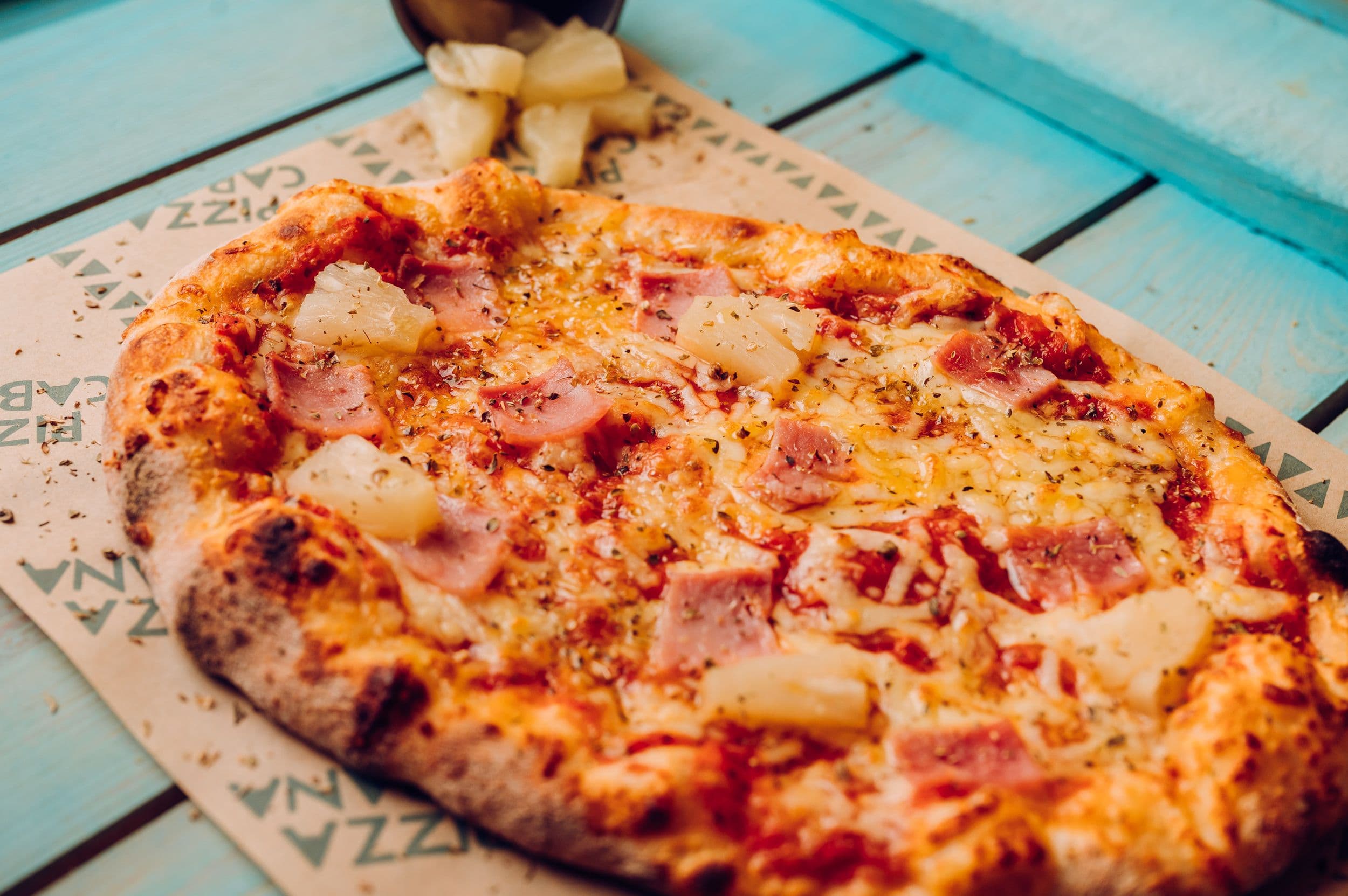 A close up of a tropical pizza with pineapple at Treetop Golf.