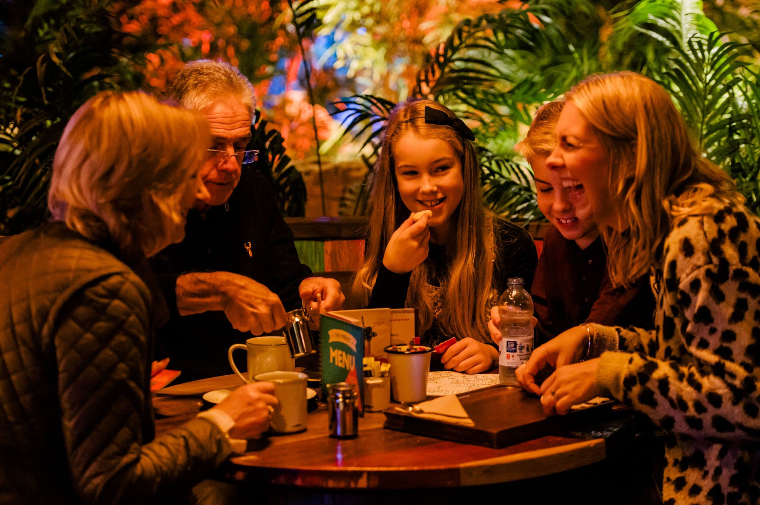 Family sitting down at the Market laughing.