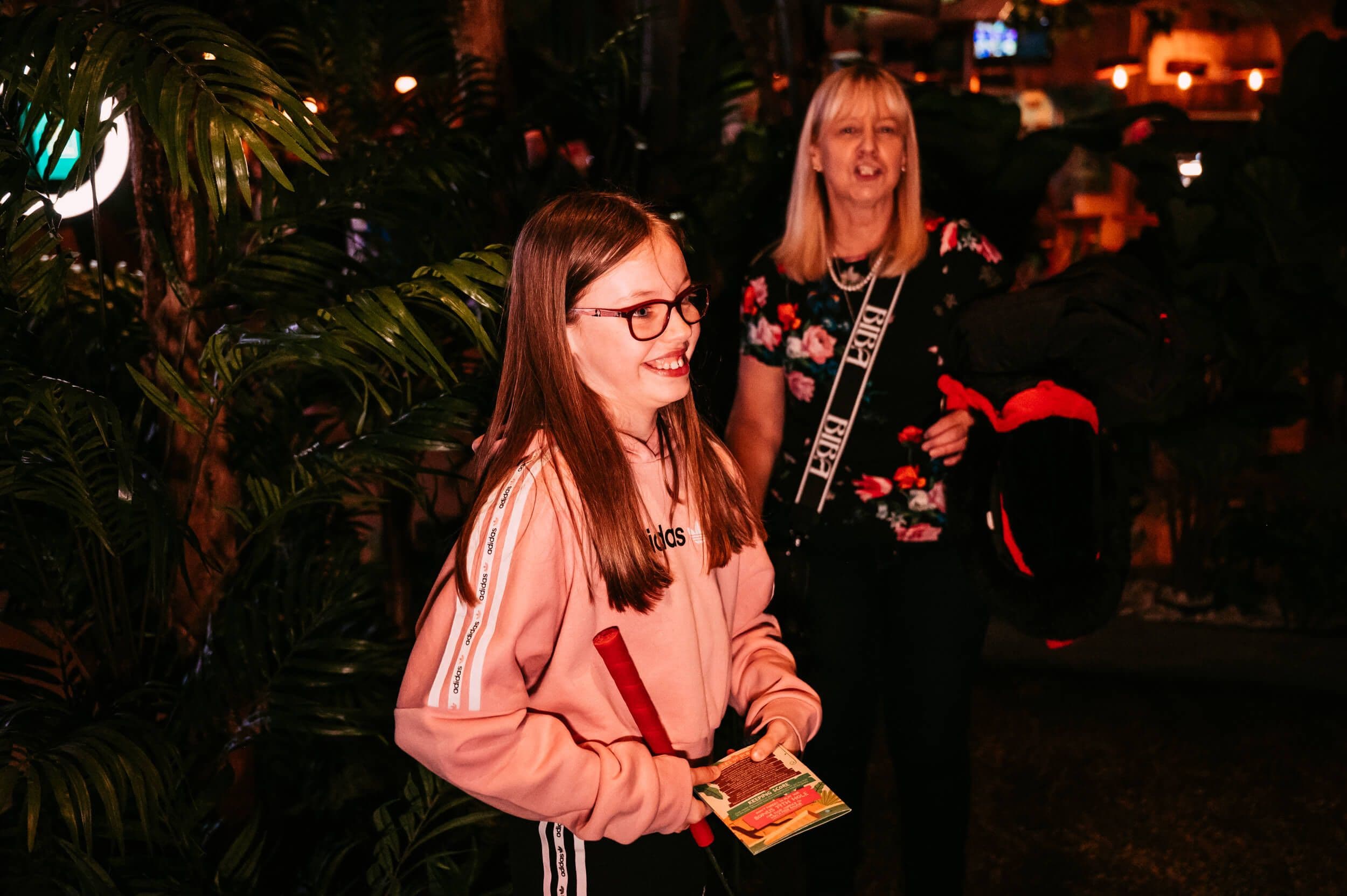 Young girl and her mother hold a score card as they enter the Treetop jungle.