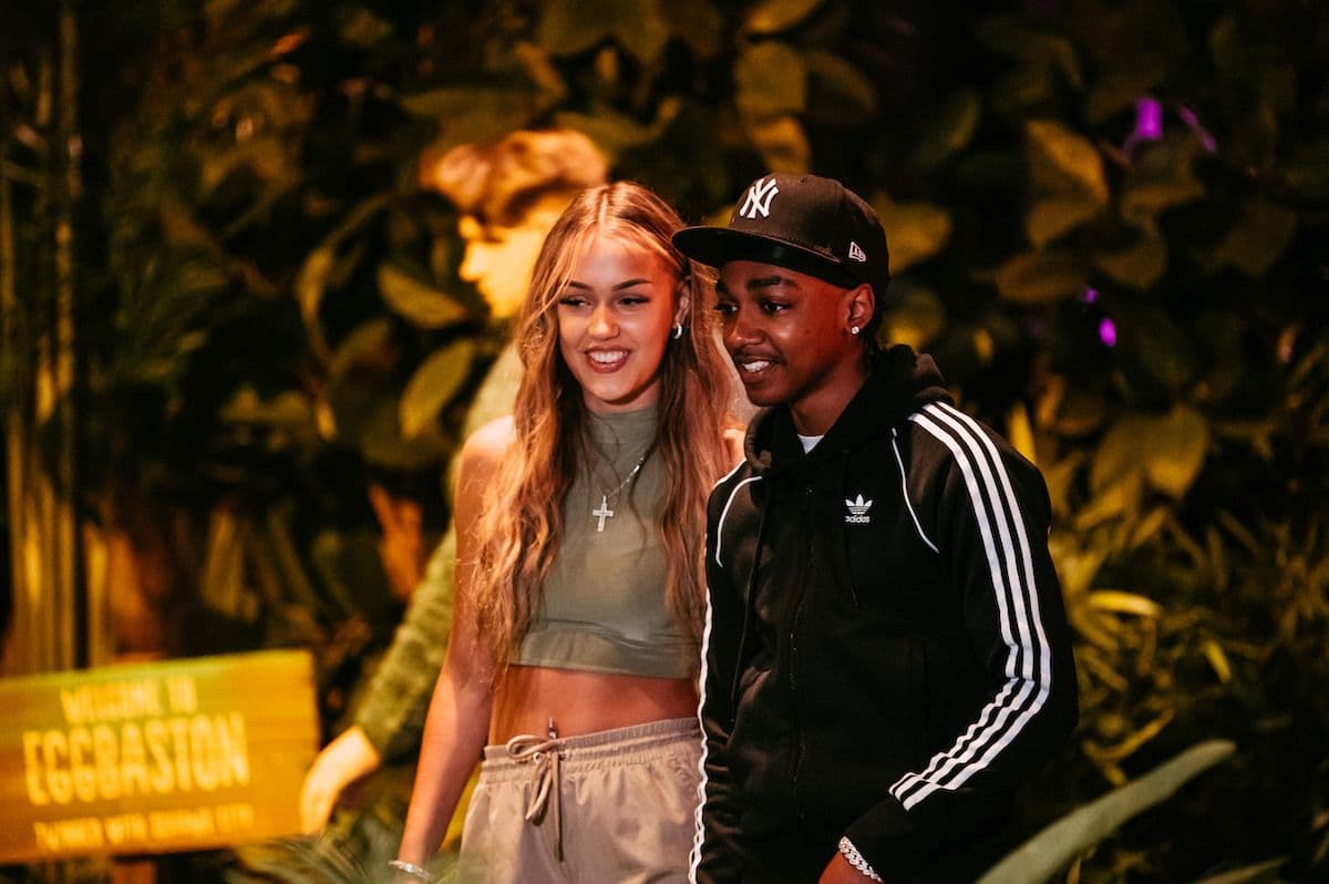 Two teenagers playing mini golf and smiling.